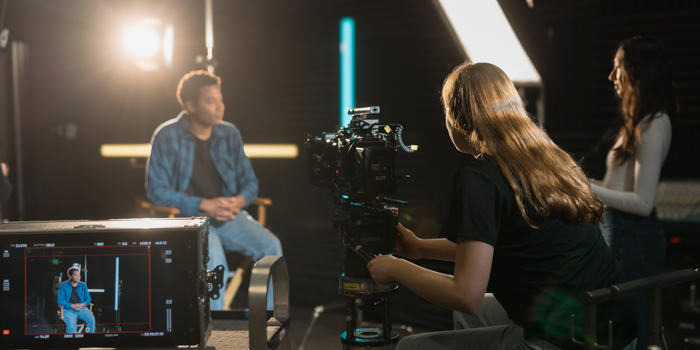 Students filming an interview in a studio setting.
