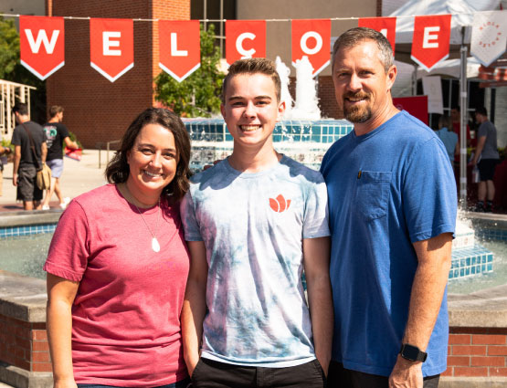 middle-aged man and woman smiling with a young man