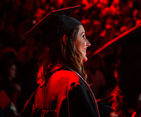 Young woman wearing a cap and gown at graduation