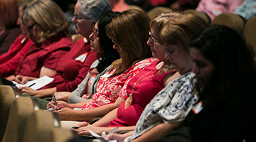 Staff listening during a conference session
