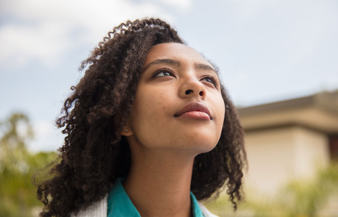 A female student looking up into the distance reflectively