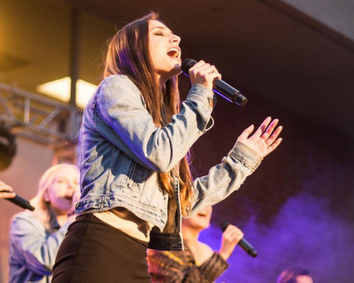 Female vocalist singing at a concert. 