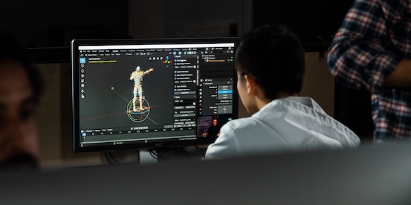 Design student sitting at a computer editing a 3D project