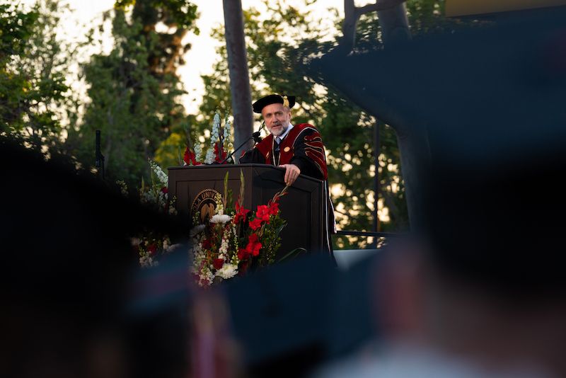 Image shows Dr. Corey speaking at Commencement