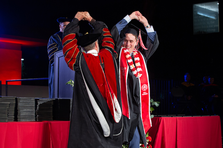 Image shows Dr. Corey doing a handshake dance with his son