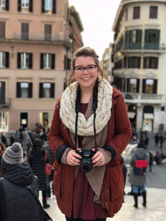 chloe standing in Rome street with camera