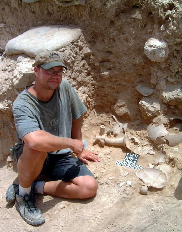 Kenneth Way sitting near  vessels which contain organic remains from ninth-century BC Philistia