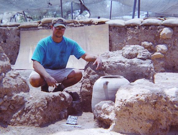 Kenneth Way next to vessels which contain organic remains from ninth-century BC Philistia