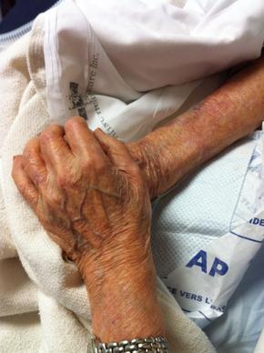 Dr. Jung's mother holding Sam Joe's hands in his final moments