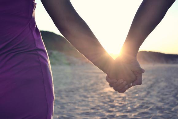 Couple holding hands on the beach