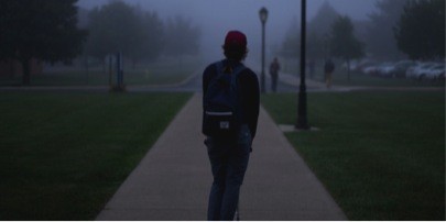 Student standing outside on a dark night