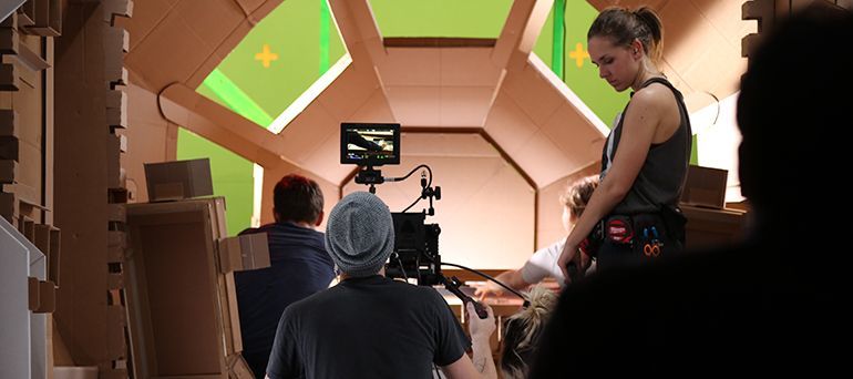Students filming in a spaceship set.