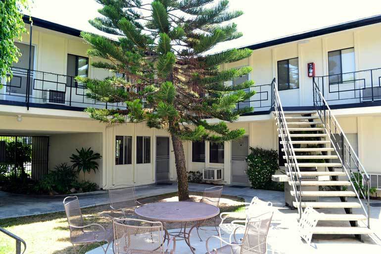 Courtyard of Lido Mirada apartments with stairway and large tree