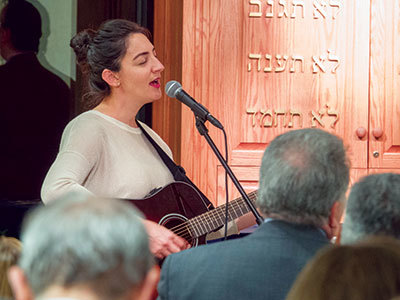 Woman leading worship at the Feinberg Center in Brooklyn