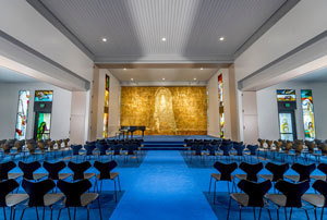 Front of Calvary Chapel with gold relief, stained glass on either side, and vibrant royal blue carpet