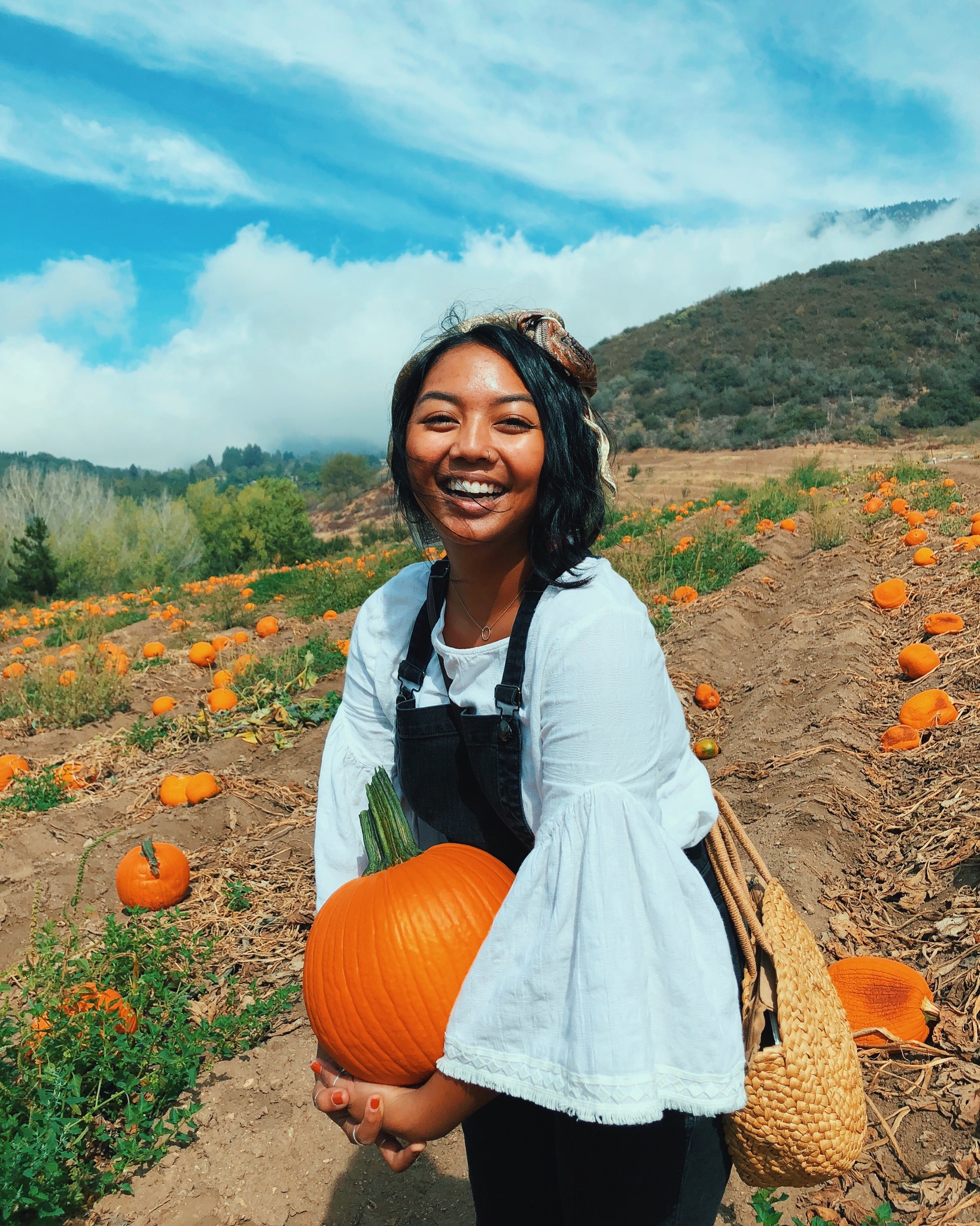 Photo of Aubrey holding a pumpkin at Riley's Apple Farm