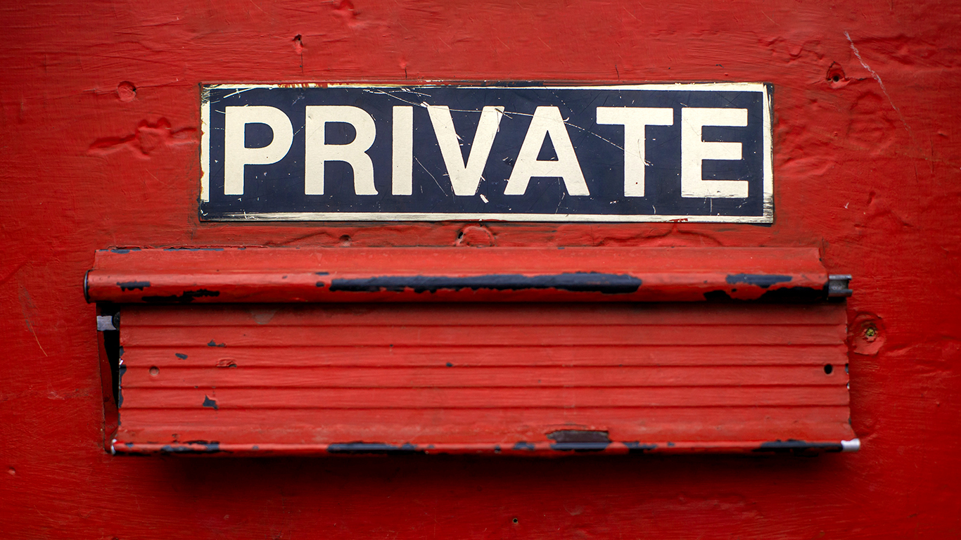 A mail delivery slot in a red door has a sign above it that says, "Private."