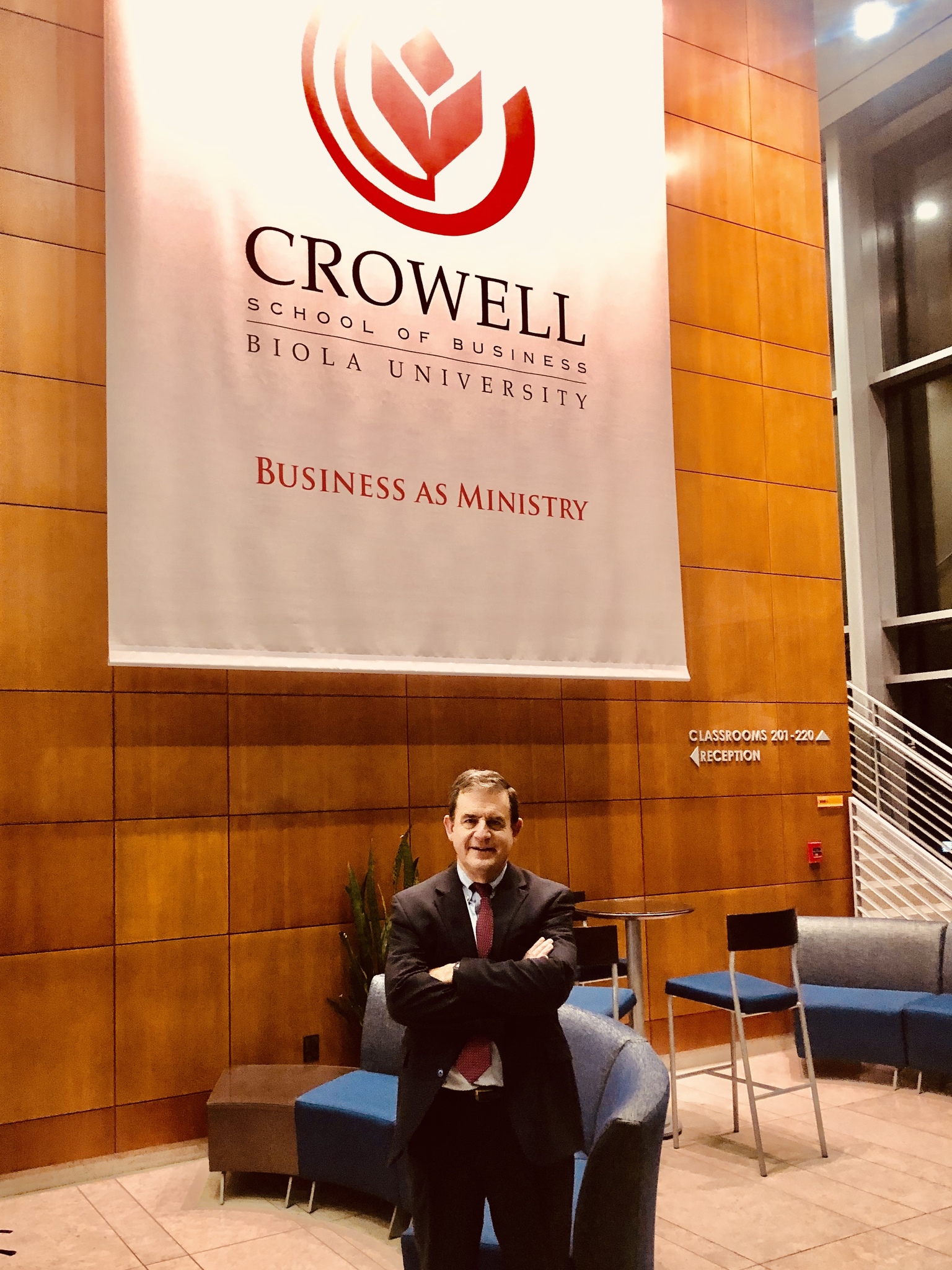 Bob Doll in front of Crowell lobby banner