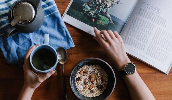 A bowl of oatmeal, tea and a relaxing book