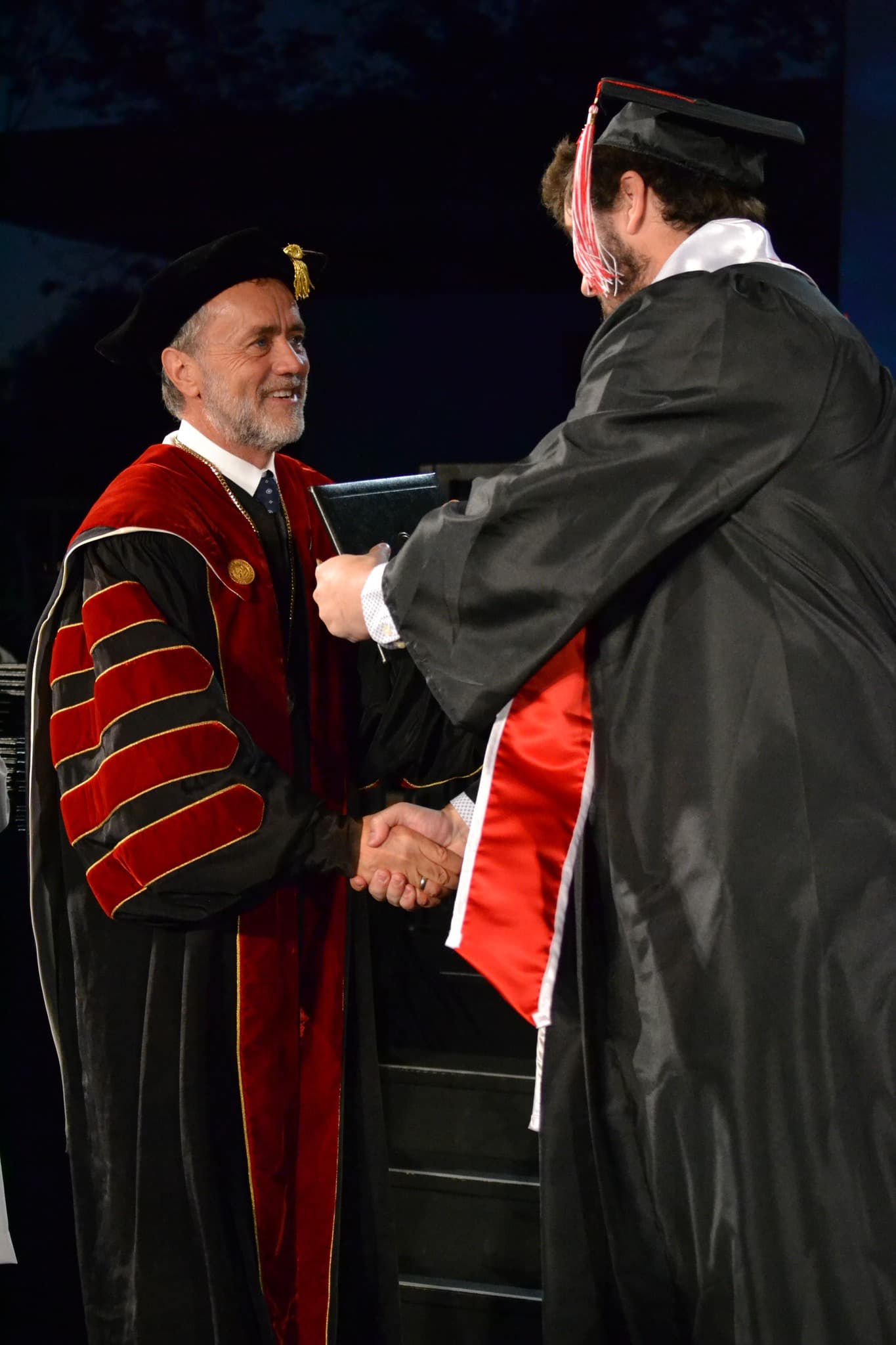 image shows a student shaking hands with Dr. Corey