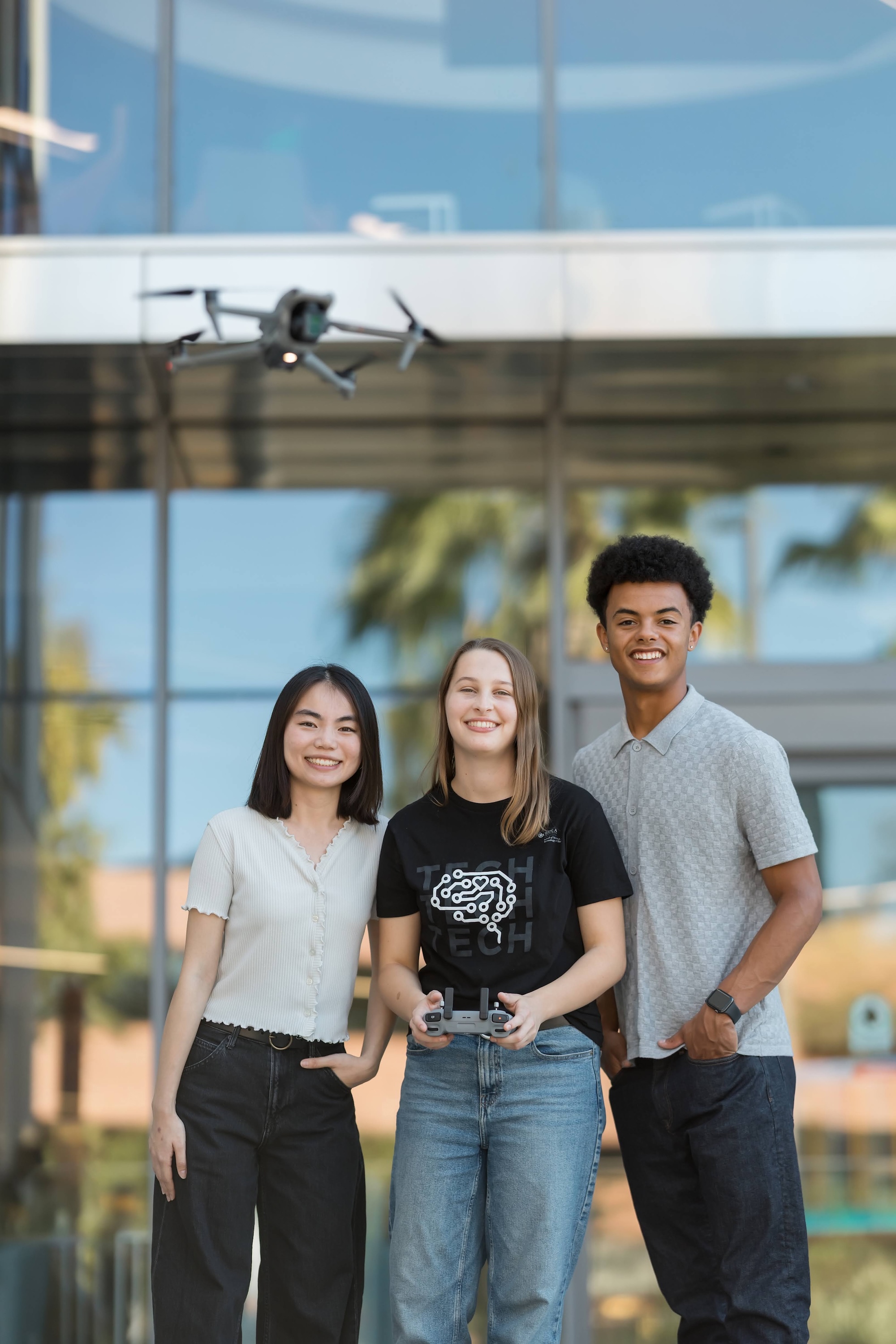 image shows students controlling a drone