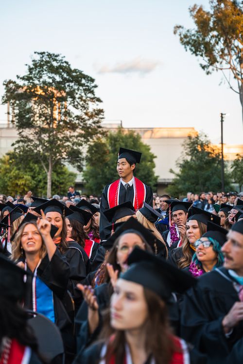 Image shows a graduate standing