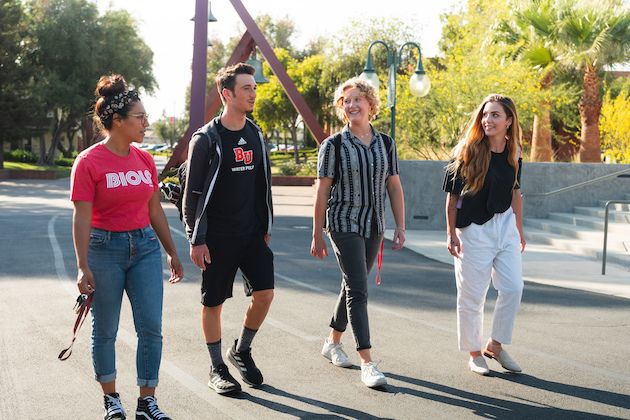 image shows 4 students walking on Biola's campus