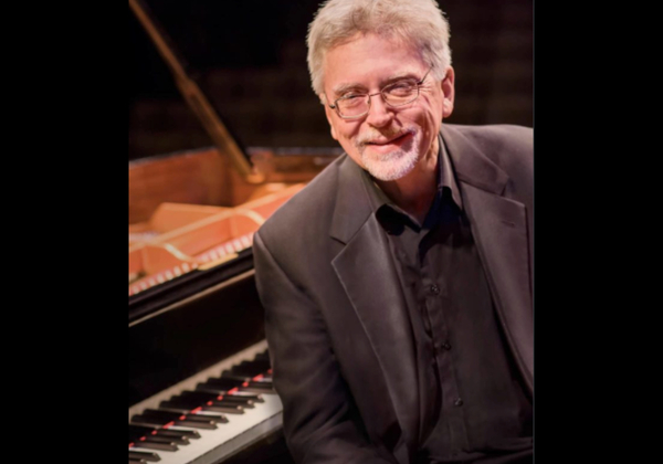 Mr. McDonald sitting at the piano