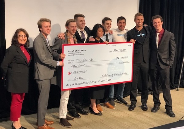 Photo depicts a past startup competition team receiving their winning check