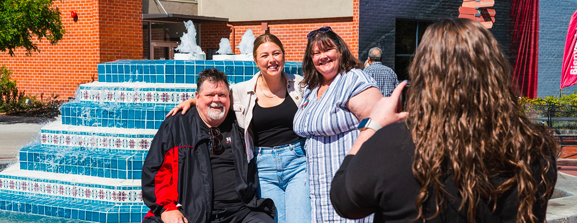 female student with parents in front of fluor fountain