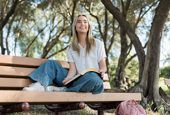 student sitting on bench outside