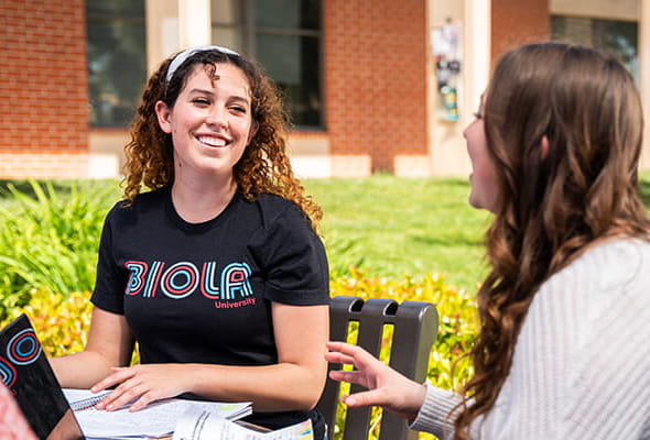 Students sitting together outside at a table