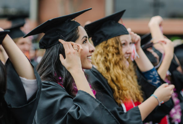 student at commencement wearing caps and gowns