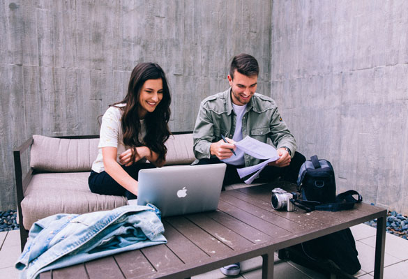 A female and male student studying in an outdoor lounge area