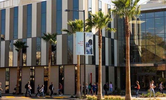 Image shows the Lim Science Center with students walking in front of it. 