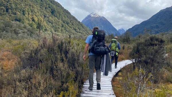 two young men with backpacks hiking 