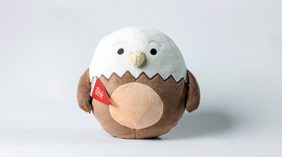 a plush eagle carrying a Biola pennant