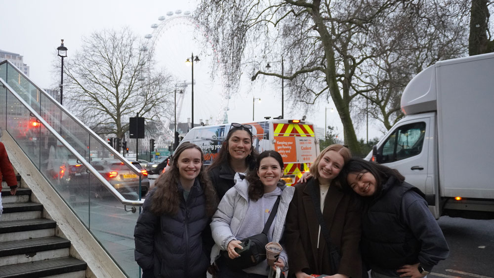 Group of students with city life and ferris wheel in the background