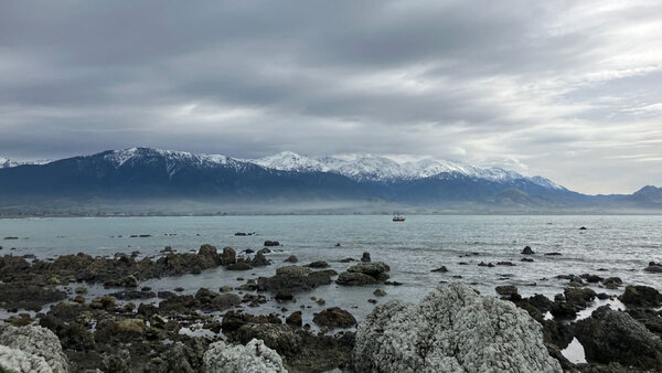 a rocky beach with mountains in the background