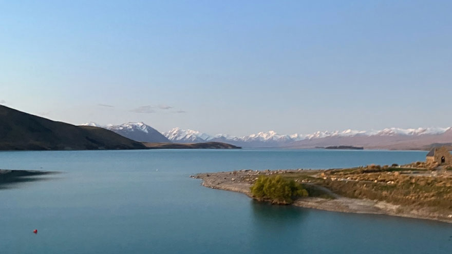 a large lake with snowy mountains