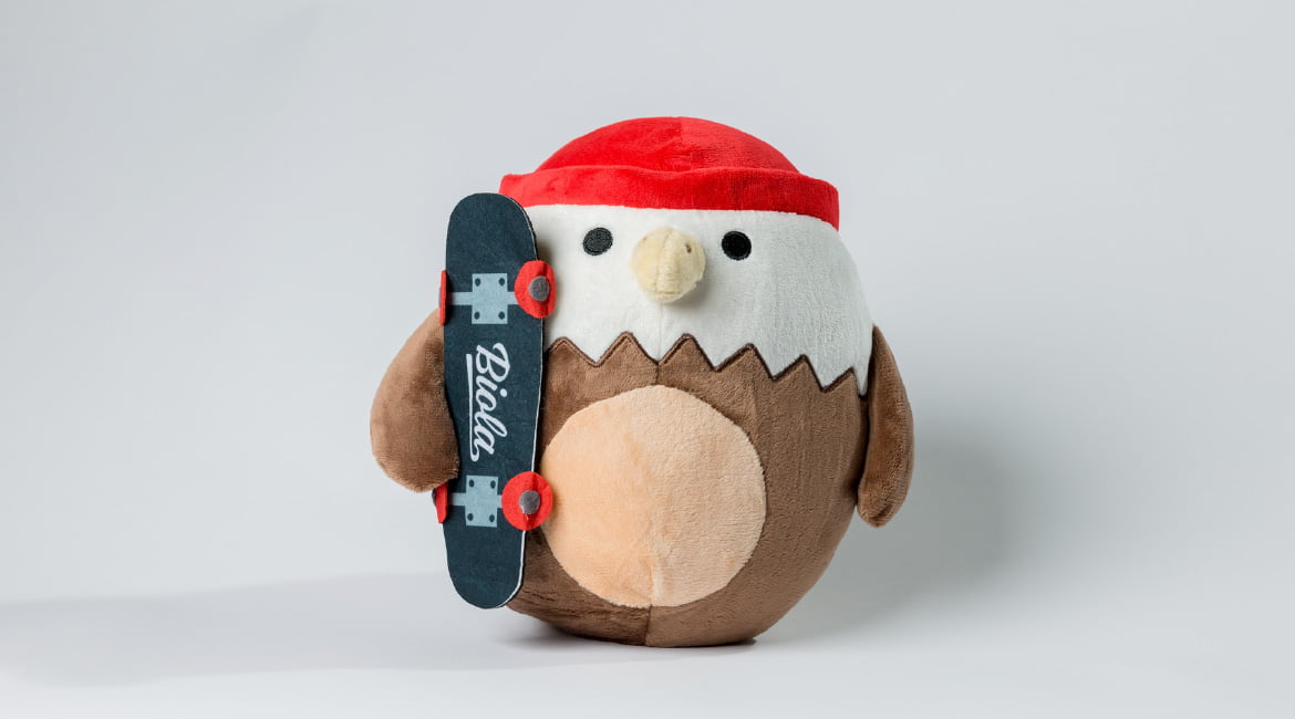 a plush eagle wearing a beanie and holding a skateboard